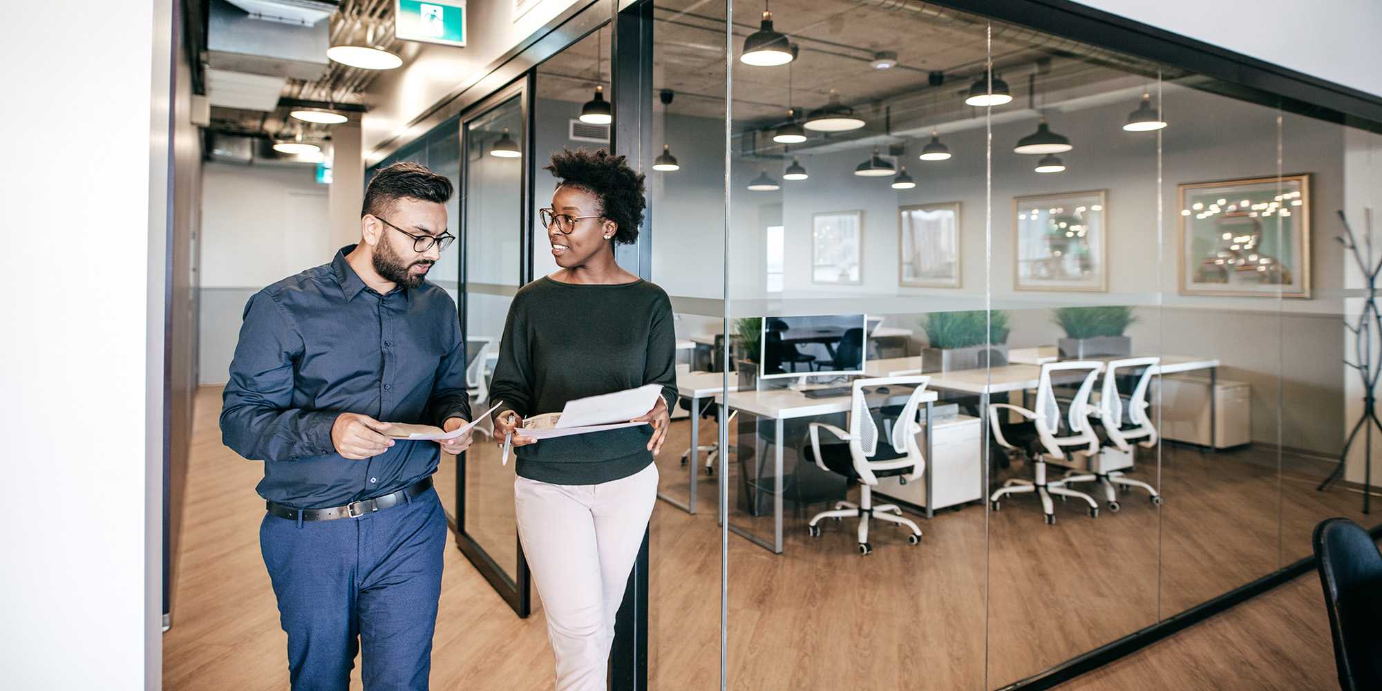 two professionals discussing Houston's latest office real estate market conditions in a modern office